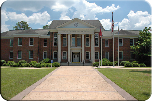 The historic Bryan County Courthouse in Pembroke, Georgia, a red brick building with white columns.